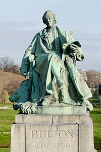 Bronze statue of Buffon wearing a ruffled shirt and a long coat, holding a bird with wings spread.