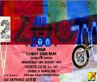 A multi-coloured rectangular concert ticket, displayed horizontally. Small icons are scattered in the background. It bears the logo of a satellite and features details of the concert, along with the text "U2 Zooropa '93 Zoo TV Tour".