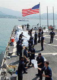 USS McFaul (DDG 74) sailors unload humanitarian supplies.jpg