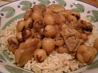 Closeup of large round speckled beans cooked with cubes of pork over rice
