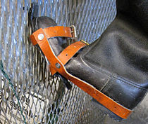Close-up view of a boot which has been modified with a hooked overshoe, shown on a section of border fence to demonstrate how it would have been used to climb it.