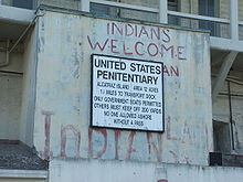A sign that reads United States Penitentiary has graffiti above it saying "Indians Welcome".