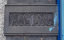 The initials AL&GD Co Ltd in ornate script, carved into a flat column