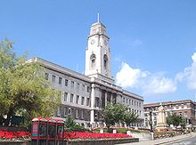 Barnsley Town Hall on a fine day.  The Town Hall itself is visible behind some gardens; the building is made of white stone and has an impressive clock tower