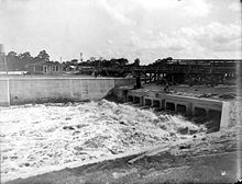 A black and white photograph of a canal lock built in the Everglades, directing millions of gallons of water toward the Atlantic Ocean