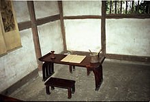 Sparse room with a wooden bench and writing desk