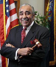 Official pose of Rangel holding a gavel, dressed in a suit and in front of an American flag