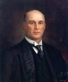 A painted portrait of an unsmiling bald white man in a three piece suit