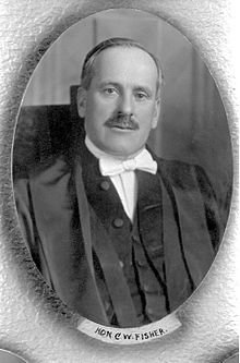 A formal portrait of a moustached man in formal robes and a white bowtie.