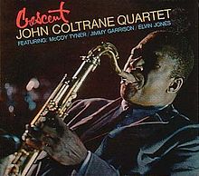A slanted photograph of Coltrane playing saxophone in a blue suit facing the left. The top left corner of the cover features the title of the album in red script with by the words "John Coltrane Quartet" in yellow beneath it and "Featuring McCoy Tyner/Jimmy Garrison/Elvin Jones" underneath that in blue.