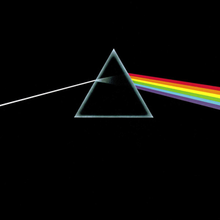 A small grey equilateral and hollow triangle sits slightly above the centre of an opaque black image.  A perfectly straight light-grey line enters from the middle of the left edge of the image, and is angled slightly upward to meet the left side of the triangle.  Inside the triangle the grey line expands slightly, fading to black as it reaches the centre. On the right side of the triangle a thick bar composed of red, orange, yellow, green, blue, and violet angles downward to the middle right edge of the image.