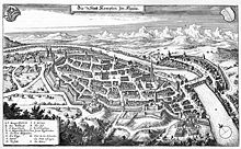 A finely detailed drawing of an old city, with church towers, thick defensive walls, moats, and lots of houses.