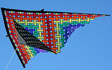 A colorful triangular kite against a blue sky
