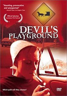 Red-tinted DVD cover with the film title featuring a girl in white Amish-style bonnet and dark plain dress, seated in the back seat of a car, lighting a cigarette.