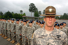 A drill sergeant posing before his company
