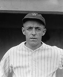 A man wearing a pinstriped baseball jersey and a cap with the letter "W" written on the front.