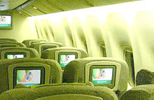 Airline premium economy cabin. Rows of seats arranged between aisles.