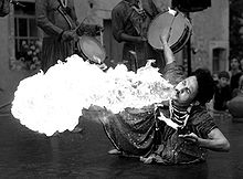 A grayscale image showing the HSV value component of the photograph leaves the flame completely white (in photographer's parlance, "blown out"), and the man’s clothing much too bright.