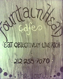 A wooden sign displays the words 'FountainHead Cafe: Eat Objectively, Live Rich'
