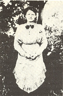 Young woman wearing an apron and facing forwards