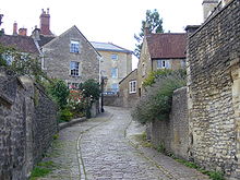 Narrow street between stone walls and houses