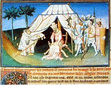 Colorful painting from an illuminated manuscript, showing a tent with a dignified and crowned bearded man seated in a chair in front of the tent's opening. A cowled monk kneels on the left, offering something to the man in the chair. Several figures in armor are standing to the right, deferential to the man in the chair.