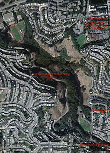 Aerial photograph showing a park surrounded by houses.}}