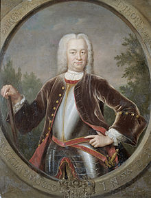 A portrait of Governor General van Imhoff in a large white wig and black suitcoat over plate armour. He is carrying a cane in his left hand and has a sword sheathed on his right side.