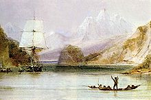 On a sea inlet surrounded by steep hills, with high snow covered mountains in the distance, someone standing in an open canoe waves at a square-rigged sailing ship, seen from the front