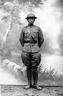 Man in military uniform with shoulder and waist belt with helmet