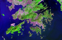 Topographical satellite image with enhanced colours showing areas of vegetation and conurbation. Purple areas around the coasts indicate the areas of urban development