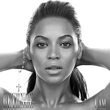 The cover of the album "I Am... Sasha Fierce" features the face of Beyoncé Knowles. She is looking directly to the camera while she keeps her hands behind her head. Her hair is combed with a ponytail, and she wears a bracalet on her right wrist. At the lower left corner her first name is written in capital silver letters, while "I Am..." is written with the same pattern at the right corner.