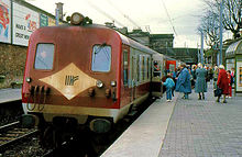 Diesel train standing in station with passengers boarding