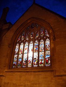 A night scene of a stained glass window lit from inside