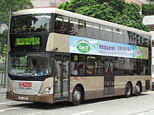 A dark tan double-decker bus with advertising-banner promoting clean environment.