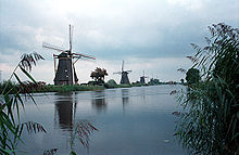 Typical Dutch scene with a series of windmills along the waters edge