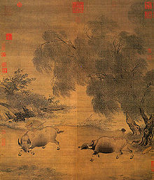 A square painting depicting two oxen fighting against each other at the bank of a river. The ox to the right appears to be trying to turn around to face the ox to the left, while the ox to the left seems to be charging straight at the ox to the right.