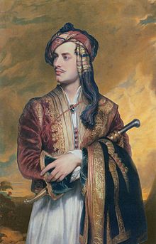 Half-length portrait of pale man in his mid twenties, sitting in red coat with gold trim. His left hand is holding an obscured tubular object that is pressed against his body. His dark brown hair is wrapped in an orange and red bandanna, and he has a thin moustache.