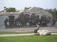 Photograph of a park in Beijing, showing a stone relief carving of a Mongol caravan