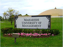 A photograph of a dome. A sign in the foreground reads "Maharishi University of Management".