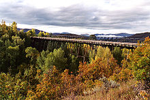 The bridge seen from a greater distance, with trees in front and below changing color