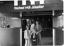 Michael Hill and family standing outside the entrance of their first jewellery store
