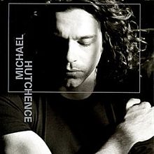 A black-and-white photo of Hutchence lying down with a thin grey square superimposed around his face and his name written vertically on the left-hand side in grey.