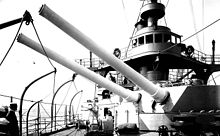 two large rifled cannon pointing out of a turret, aimed over the side of the ship.