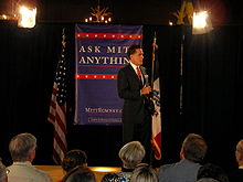 Mitt Romney addressing an audience from atop a stage