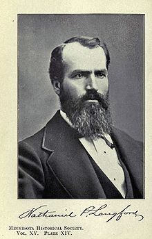 A middle-aged man in formal attire with a beard