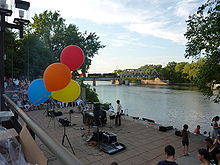 Band playing in the mid-distance, bright balloons in the foreground