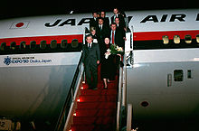 Japan Prime Minister Noboru Takeshita and eleven others deplanes on steps in red colour, from a Japan Air Lines DC-10 marked with an Official Airline for Expo '90 Osaka, Japan logo and text