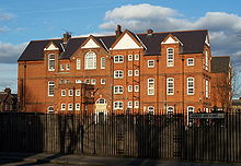A large red and yellow brick school of a similar Gothic design to the previous photographs of houses but on a much larger scale