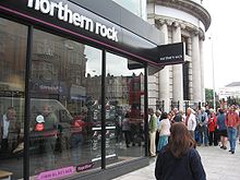 A number of people queuing at the door of a branch of the Northern Rock bank.